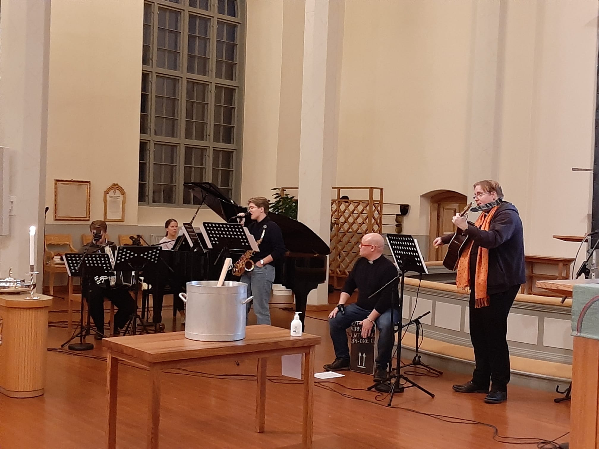 Ihmiset soittavat instrumentteja ja laulavat Orimattilan kirkossa
