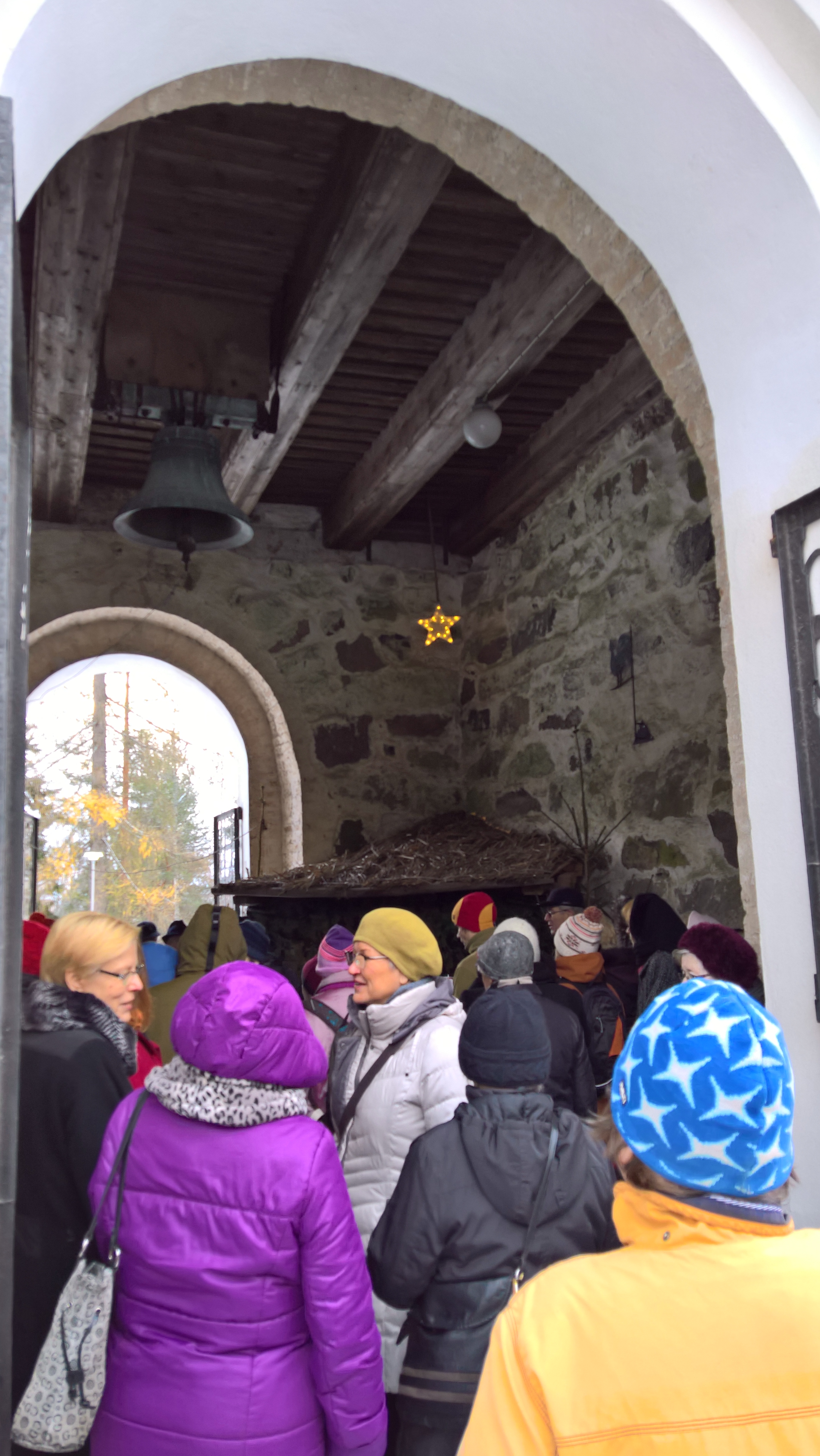 Iltakävelyllä kellotapulin liepeillä klo 17-19 Ihmisiä kirkon kellotornin alaosassa seimen luo menossa